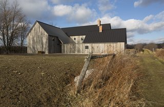 An Artist and Farmer Work With a Toronto-Based Studio to Build a Barn-Inspired Home - Photo 7 of 11 - One of the pitched roofs extends to the ground, concealing an entrance. 