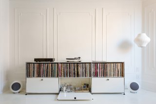 A Pair of Designers Renovate Their Brooklyn Brownstone With a Bright Monochromatic Palette - Photo 6 of 12 - The large front parlor was turned into a music room that flows seamlessly into a long dining room. A USM credenza holds vinyl and booze. Music flows via a Pro-Ject Debut III turntable, a pair of Elipson Planet L speakers, and a Music Hall Audio amplifier. 