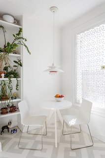A Pair of Designers Renovate Their Brooklyn Brownstone With a Bright Monochromatic Palette - Photo 7 of 12 - In the kitchen, a PH 50 pendant by Poul Henningsen for Louis Poulsen hangs overhead; the window is covered in a decorative cast-iron metal security grate from King Architectural Metals. The painted patterned floor is by Lillian Heard Studio. 