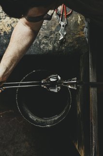 Master Glassmaker Simon Pearce's Sustainable Factory in Vermont - Photo 14 of 16 - Reheating After the glass has been reheated in an oven called a glory hole, the jacks are used to open the mouth of the cup. 