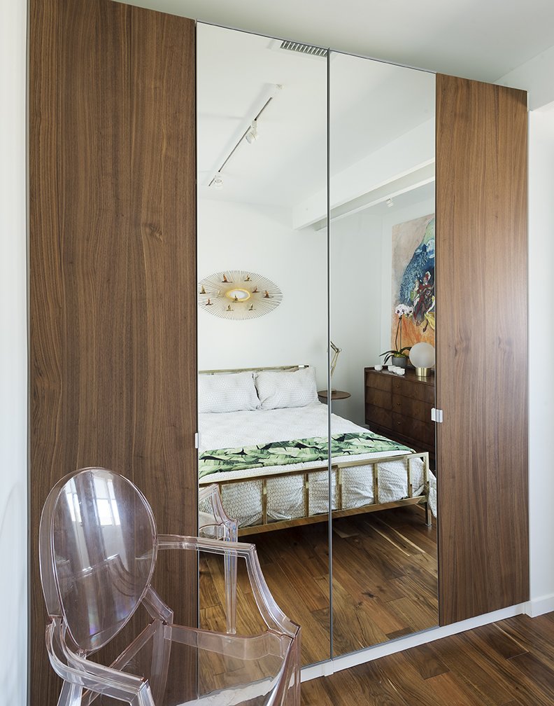 A Curtis Jere sculpture hangs  above a bed from CB2 in the upstairs guestroom. The Louis Ghost chair is by Philippe Starck  for Kartell.