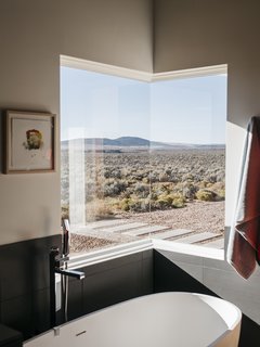 A Rookie Designer and Her Builder Father Create an Artist's Sculptural Loft in the Desert - Photo 7 of 10 - The master bathroom features one of two corner windows in the house. "At night, when I take a bath, I can see the moon and the stars," says Lois. 