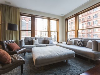 Experience New York City's Eclectic Side at One of These Modern Short-Term Rentals - Photo 1 of 11 - With a large roof terrace, a master bedroom with dramatic arched windows, a bedroom with curved-glass walls, and a floating glass staircase, this elegant townhouse evokes the vintage cool of a Mad Men set.
