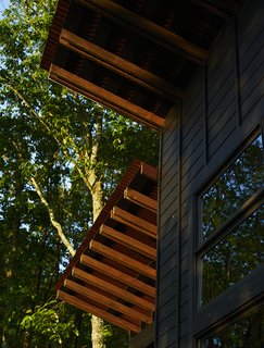 A Rustic-Modern Cabin Inspired by Japanese Bungalows and Shou Sugi Ban - Photo 2 of 12 - The home’s board-and-batten siding is black-stained pine punctuated by Jeld-Wen windows.