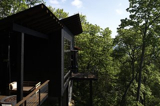A Rustic-Modern Cabin Inspired by Japanese Bungalows and Shou Sugi Ban - Photo 8 of 12 - One of the pitched roofs shelters a side deck, which has a SwingLab bench.