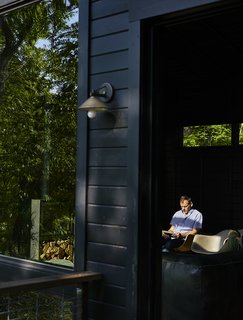 A Rustic-Modern Cabin Inspired by Japanese Bungalows and Shou Sugi Ban - Photo 10 of 12 - A recessed sliding door by Jeld-Wen opens from the kitchen onto a perch deck. 