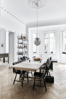 A Careful Renovation of a 19th-Century Flat in Gothenburg Brings it Back to Life - Photo 6 of 11 - A Snowball pendant by Poul Henningsen for Louis Poulsen hangs in the dining room; the J46 chairs are by Poul M. Volther. 