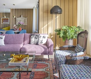 An Interior Designer Helps His Mother Turn Her 1960s Chicago Apartment Into a Colorful Haven - Photo 1 of 8 - Eleni Katsarou’s new Chicago apartment is an explosion of color. Graphic Fornasetti pillows rest on a pixelated-pink Carlton sectional by BoConcept next to cane back chairs upholstered in Quatrefoil fabric by Alexander Girard. 