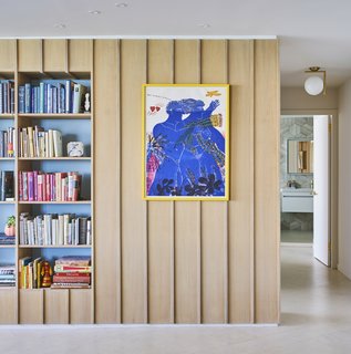 An Interior Designer Helps His Mother Turn Her 1960s Chicago Apartment Into a Colorful Haven - Photo 5 of 8 - An Alekos Fassianos lithograph and soft blue niches offset the wood paneling. An IC lamp by Michael Anastassiades hangs in the hallway.