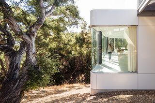 The Conversation Pit Makes a Much-Appreciated Comeback at an Ultramodern Home in Cupertino - Photo 3 of 9 - The main living area is cantilevered into the tree canopy, while bedrooms, bathrooms, service, and storage are located behind a long wall of cabinetry against the hillside. 