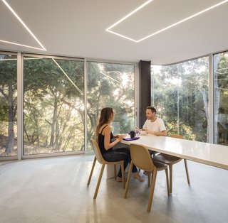 The Conversation Pit Makes a Much-Appreciated Comeback at an Ultramodern Home in Cupertino - Photo 4 of 9 - A 22-foot-long white composite quartz countertop provides both kitchen work space and a dining table. 