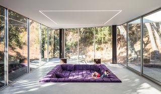 The Conversation Pit Makes a Much-Appreciated Comeback at an Ultramodern Home in Cupertino - Photo 5 of 9 - The living room features a 250-square-foot custom sofa configuration inspired by Patricia Urquiola’s Tufty-Time sofa for B&B Italia, fabricated by Furniture Envy in San Francisco. Overhead, as in the rest of the main living spaces, flush- mounted LED strips provide further demarcation of zones. 