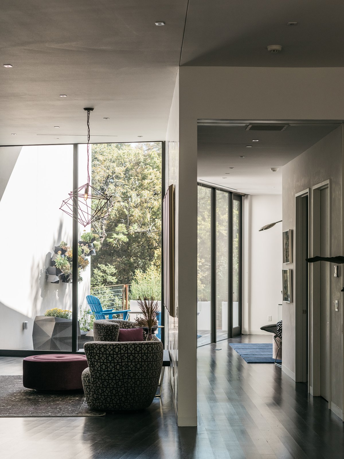 A sitting area off the main living space features chairs upholstered by Berkeley Fabrics & Upholstery and a light fixture from Lights Fantastic.