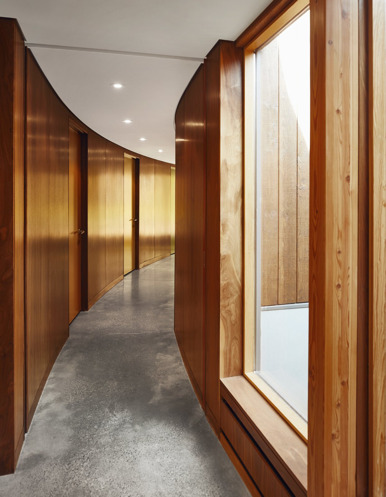 The main corridor bends 100 degrees from end to end and leads to three guest rooms, each with a different color door. “Roland took a Lawren Harris painting and matched the colors perfectly,” says David.