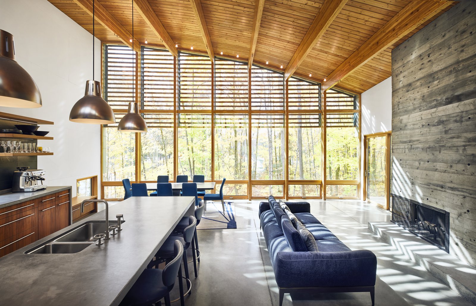 In the great room, the curved ceiling reaches 16 feet. A Roche Bobois sofa faces a double-sided, indoor/outdoor fireplace made of board-formed concrete.