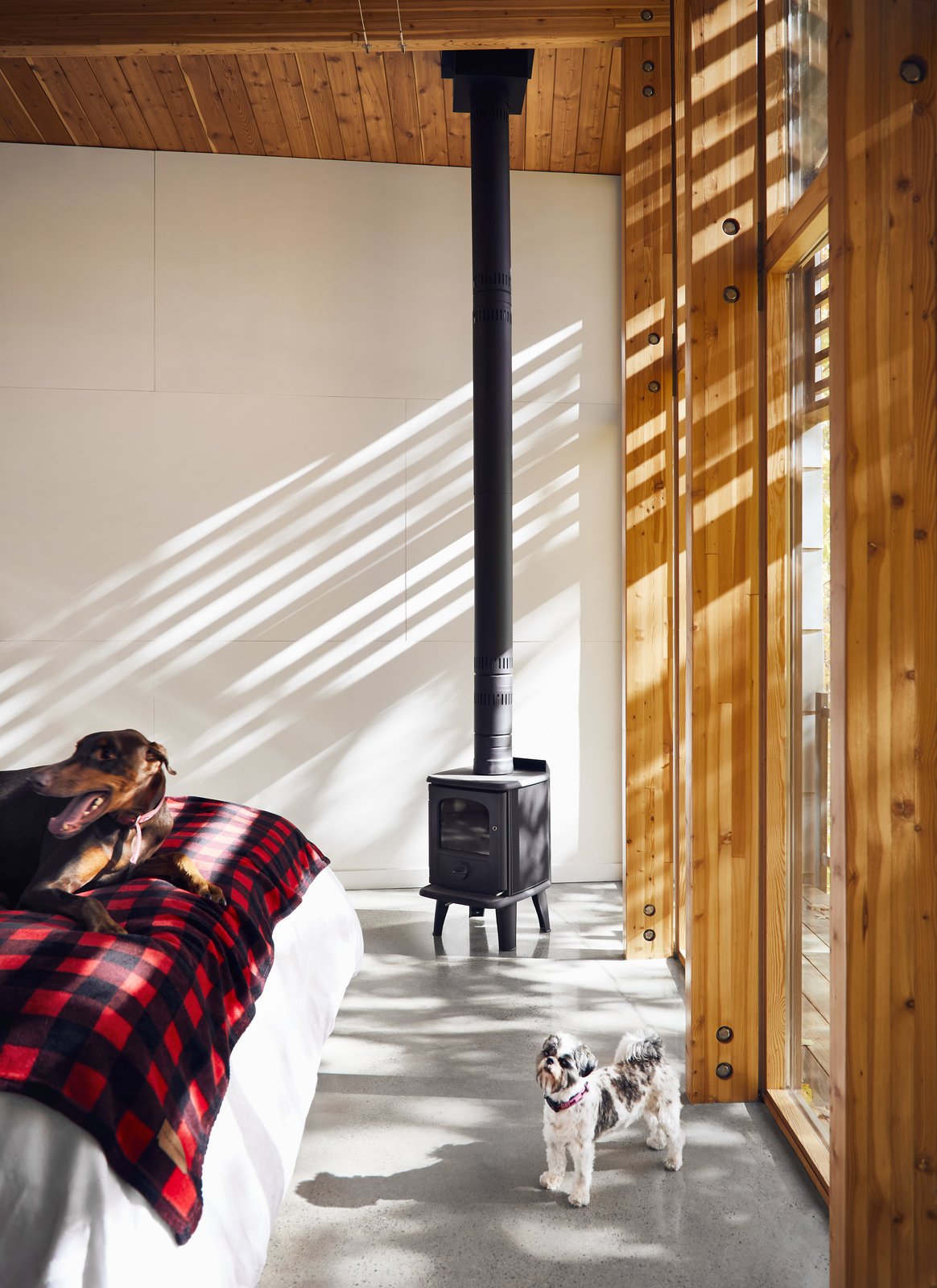 The master suite is warmed by a Badger 3112 woodstove by Morsø.