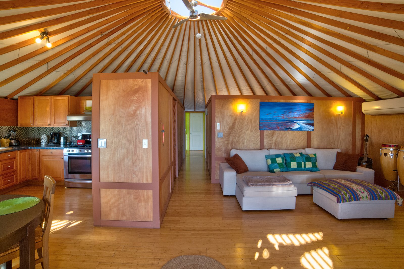 The exposed beams of the yurt lead up to a central skylight that helps the space feel bright and airy.