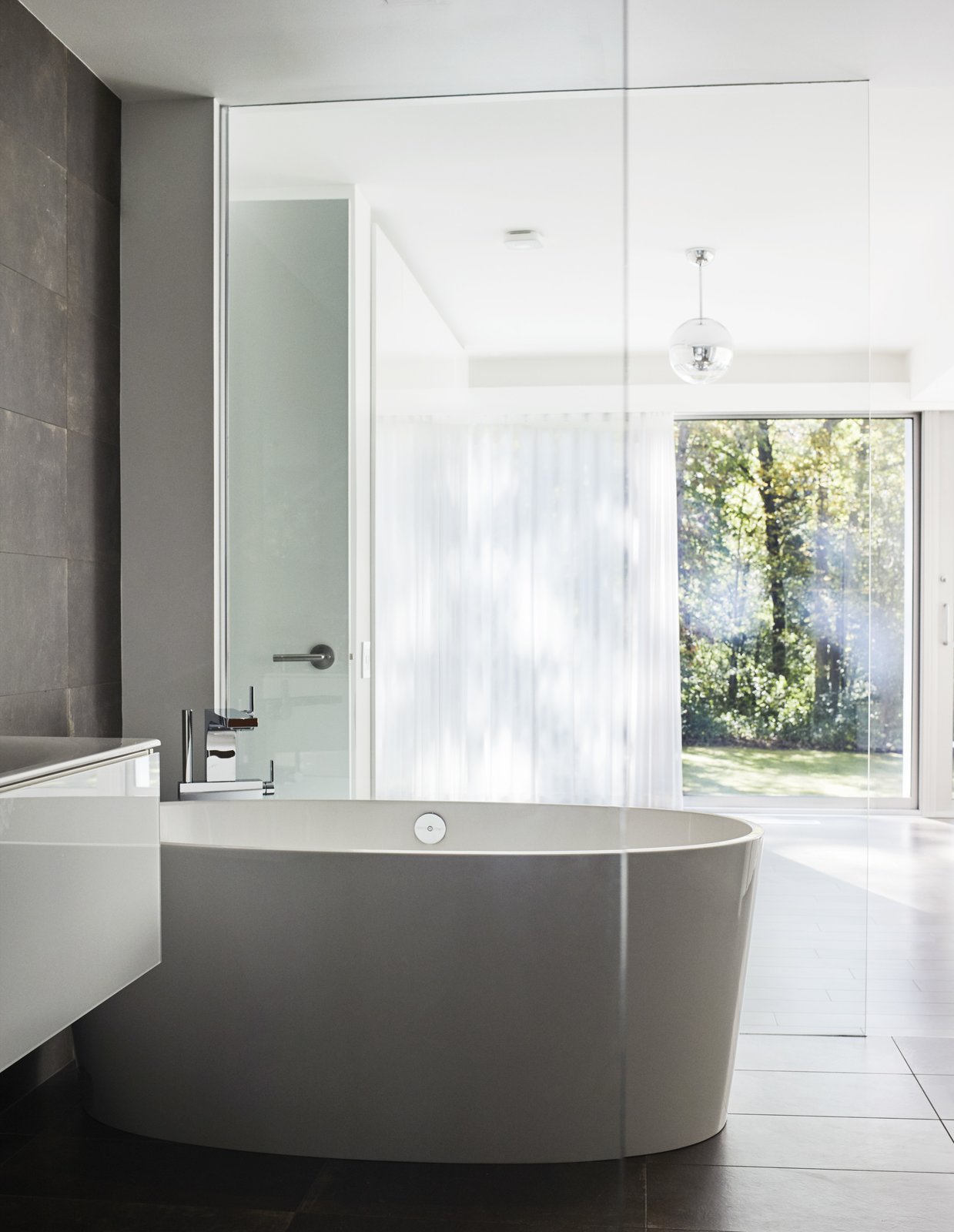 The bathtub is by Victoria + Albert and the Terre Ruggine tiles are by Iris Ceramica.