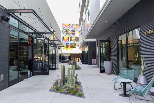 On the left, the car repair bays were repurposed and now exist as individual shops and restaurants such as Loqui Taco Bar, Blue Bottle Coffee, and Aesop. These rows of car bays used to have garage doors that opened up to a slot for the car to pull in for repair work. Now, the garage doors have been replaced with glass storefronts and these slots are the store interiors. Photo 6 of PLATFORM modern home