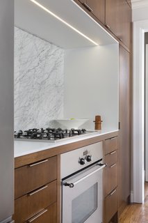 Another custom oak unit houses the oven, range, refrigerator, and pantry.