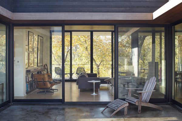 Large sliding doors connect the living room to both the courtyard and a covered porch on the western side of the house.