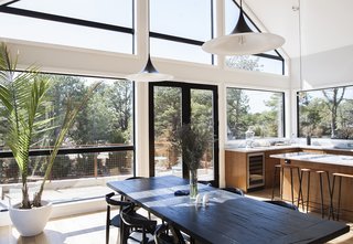 You Won't Lose Your Wi-Fi Connection at This Hamptons Retreat - Photo 3 of 6 - The interior features 16-foot pitched ceilings. Semi lamps by Bonderup & Thorup for GUBI hang over the dining table.