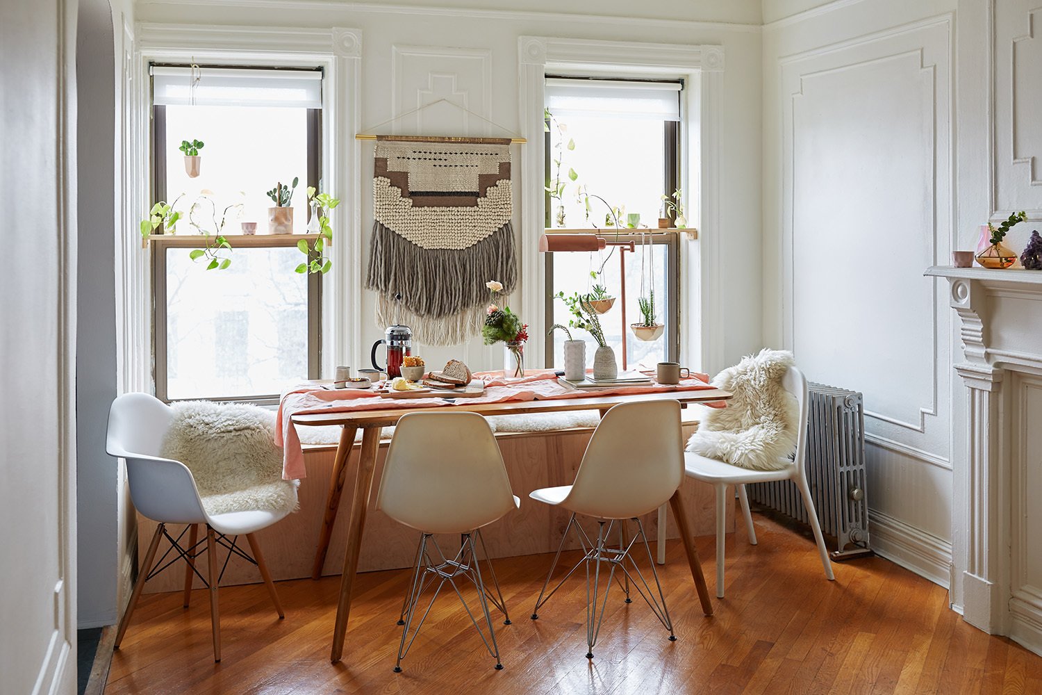 The couple's changes to the space were mostly decorative. They built the custom bench in the dining area, which holds a litter box for their cat on one end and storage space on the other. The table was purchased at The Source in Brooklyn and the wall hanging is from CB2.