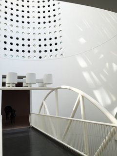 It just so happens that today was sunny as could be, and the atrium that marks the center of the building was taking it all in. The sculptural design features a bridge connecting two different gallery floors and a series of geometric windows that create a playful collection of shadows.