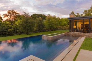Forging a Connection to the Texas Skies One Window at a Time - Photo 2 of 3 - To enhance the home's floating effect, the rear yard features a pool that conceptually emerges from additional small pools of water that extend from under the house. Once the water reaches the backyard, it then flows over the infinity edge and back onto the landscape. Courtesy of Marvin Windows and Doors.
