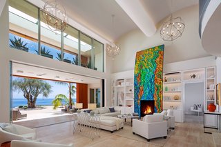 Proof That a Modern Fireplace Can Be the Defining Factor of a Space - Photo 3 of 7 - Located in the Hope Ranch neighborhood of Santa Barbara, California, this striking home sits on an almost four-acre bluff with over 200 feet of ocean contact. The art-adorned fireplace acts as the centerpiece of the living room that opens up to unobstructed views of the Pacific Ocean. 
