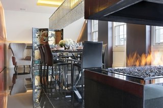 Proof That a Modern Fireplace Can Be the Defining Factor of a Space - Photo 6 of 7 - Overlooking London’s St. James’s Park, the penthouse of the Carlton House Terrace features 24-hour security and a private entrance with a concierge desk. Elevator access leads you to this renovated residence where the open stacked fireplace takes command of the dining room. 