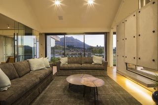 Proof That a Modern Fireplace Can Be the Defining Factor of a Space - Photo 7 of 7 - Constructed of precast concrete panels, this contemporary home in Queenstown, New Zealand was named the winner of the Gold and Lifestyle Awards at the 2015 Registered Master Builder House of the Year awards. Dividing the living and dining spaces, the slab fireplace runs the length of the living room and contrasts smoothly with soft timber woods that are utilized throughout the rest of the home. 