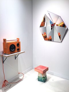 Must-See Discoveries from San Francisco’s Design + Art Fair - Photo 6 of 13 - Stonefox Architect’s mirror series includes five different faceted shapes in five high-gloss colors. Each mirror started with flat pieces that were fit together like a puzzle. Standing below the mirror, is Kueng Caputo’s Sand Chair, formed out of Styrofoam, mortar, sand, and bright-colored pigment pastes. Also shown here is Tom Sachs's Mythologies, a mixed media art piece that mimics a speaker—and actually works.