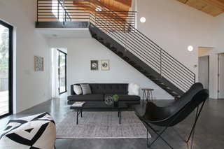 The living space sits underneath metal stairs that lead up to the mezzanine. Loewinger worked with a local metalworker to create the staircase. She purchased the furnishings from both HD Buttercup and CB2. 