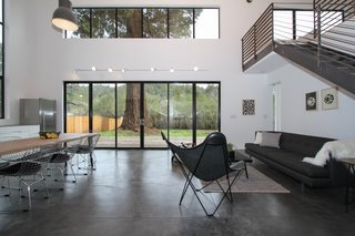 Loewinger worked with Blomberg Window Systems to outfit two sides of the house with sliding doors and an overhead layer of windows, both encased in black metal. When you’re standing at one end of the house, you can see through the far windows, all the way to the other end of the property. 