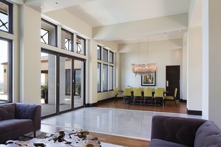 This House Takes on Gusty Winds and an Earthquake Fault - Photo 3 of 9 - Upon entering from the front, you’re greeted by an open layout designed by Zampino with a living space on one side and the dining space on the other. The sets of windows framing each of these spaces were ordered custom through Marvin. Garcia worked with a local representative who helped him with his special orders each step of the way. 