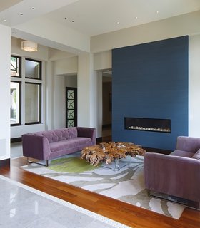 This House Takes on Gusty Winds and an Earthquake Fault - Photo 4 of 9 - A closer look at the living space near the entrance reveals a modern fireplace that’s built into a blue accent wall. 