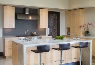 This House Takes on Gusty Winds and an Earthquake Fault - Photo 8 of 9 - The kitchen features a waterfall counter made of the same marble that covers the rest of the surfaces. 