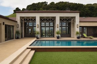 This House Takes on Gusty Winds and an Earthquake Fault - Photo 9 of 9 - Francis designed the pool to be as close to the house as possible so that it’s protected from the wind that whips through from the other side of the house. It’s easily accessible from the interior through a selection of sliding glass doors from Marvin. 