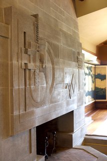 Iconic Perspectives: Frank Lloyd Wright's Hollyhock House - Photo 5 of 13 - One of the standout moments in the space is the cast-concrete fireplace, which is considered to be one of Wright’s greatest two-dimensional works of art. He completed the fireplace, a skylight above, and a moat that was designed to hold a pool of water. This was originally part of an elaborate water scheme to run through the property, though it was never completed. 