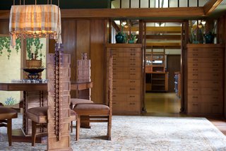 Iconic Perspectives: Frank Lloyd Wright's Hollyhock House - Photo 9 of 13 - Many of the elements throughout were influenced by his Prairie houses, including built-in furnishings, a substantial amount of wood, and art glass. The dining set was created custom by Wright and features a low seat and straight back—both signs of the Prairie style—and also boasts the Hollyhock motif running up the spine of the chair and the table’s pedestal.