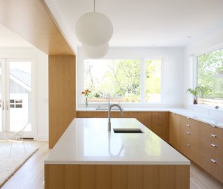 Dwell Home Tours Makes its Way to Portland - Photo 8 of 17 - Robinson punched two large openings through the primary wall in the center of the house to create a larger, more inviting living environment. The kitchen includes white oak flooring, rift-cut white oak veneer cabinets, and ceramic tile from Heath. 