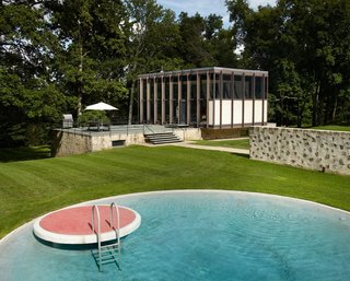 After a Year on the Market, Philip Johnson’s Wiley House Drops by $2 Million - Photo 2 of 9 - The new pool house and transformed barn that were created by Roger Ferris + Partners during a recent renovation, work together to create a courtyard that borders the original swimming pool. While a very similar circular pool can be found at the Glass House, this one features a lily pad diving platform that's finished with red tile.