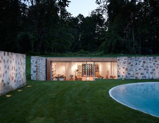After a Year on the Market, Philip Johnson’s Wiley House Drops by $2 Million - Photo 5 of 9 - Taking a peek into the new pool house that helps enclose the area, you can see how the sloped land and the original stone walls allow it to remain surprisingly hidden from the outside. 