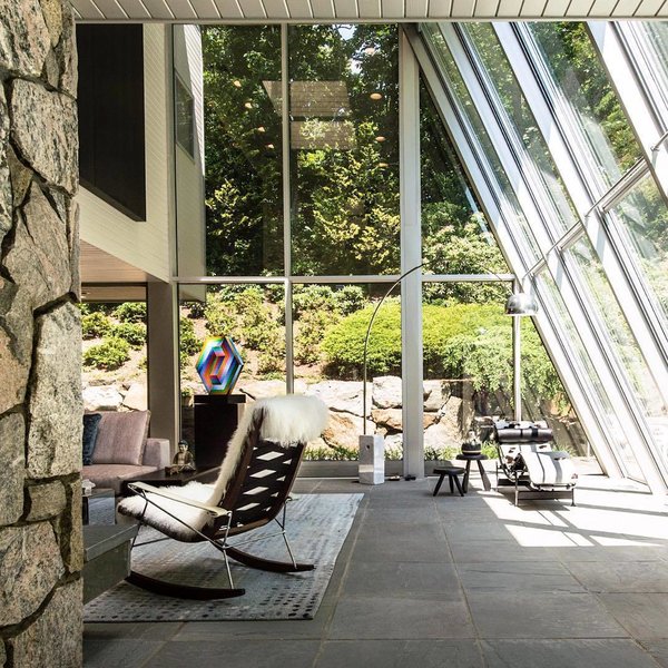 10 Enclosed Porches That Are Put to Good Use - Photo 3 of 10 - New York-based design firm Mojo Stumer Associates sent us a look into a home renovation they completed in Laurel Hollow, New York. With an interior that features a mix of textured fabrics and stone, they formed multiple seating areas throughout the glass-enclosed living space.