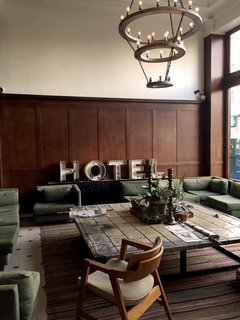 Sitting under an expansive light fixture and surrounded by street view windows is a green velvet sectional where visitors can be found day and night catching up on the news, or sipping on a cup of coffee from the adjacent Stumptown. The lobby also hosts an old-school photo booth, a shop with some quintessential Portland gear, and an old wood staircase that leads up to a lounge/office area that has the vibe of a historical library.