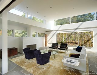 The ceiling heights were preserved throughout much of the house while skylights were placed all around the perimeter of the main structure. The living room holds an original fireplace (shown here).