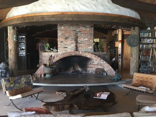 Iconic Perspectives: Harry Gesner’s Sandcastle - Photo 4 of 8 - The main house rotates around a large fireplace, where Gesner’s late wife Nan Martin used to perform for friends and family. The bones of the space is made up of old-growth redwood that was cut in the 1800s, reused telephone poles, and reclaimed wood that’s been turned into door frames, window frames, and floors. 