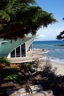 Iconic Perspectives: Harry Gesner’s Sandcastle - Photo 7 of 8 - The Wave House sits directly next to the Sandcastle on the sands of Malibu. When Gesner created it in 1957, the design had originally been born when he drew the shape of the house on his surfboard with a piece of grease pencil while he was waiting for the perfect wave. When he got back to land, he transferred it to a drawing pad and vellum before turning it into a reality. He found inspiration in the way a giant wave embraces you—and how you become a part of it. The roof is lined with copper shingles that are layered in a way that gives the impression of fish scales. 