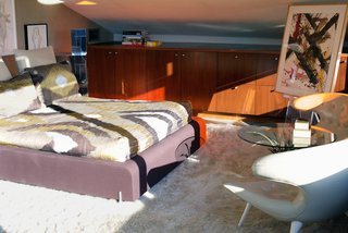 Iconic Perspectives: John Lautner’s Garcia House - Photo 5 of 8 - Shown here is the guest bedroom, which is nestled at the edge of the arched structure and is lit up by a red stained-glass window panel.